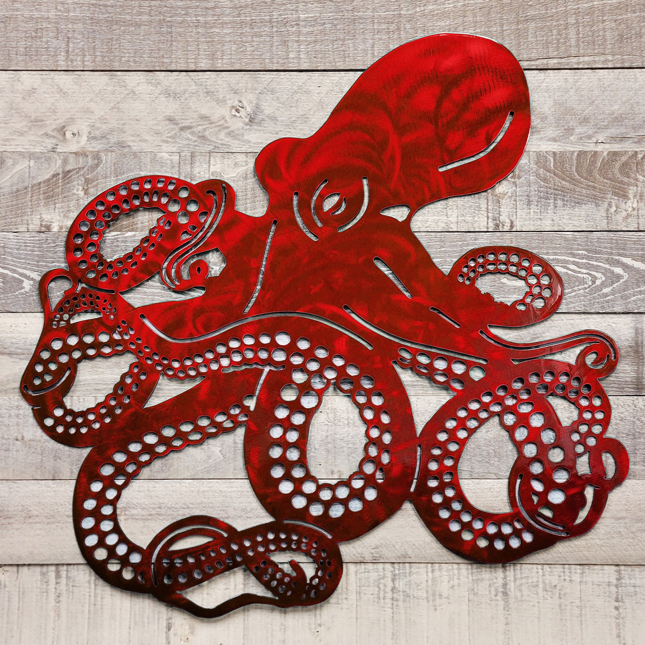 Red metal octopus wall art on a wooden background