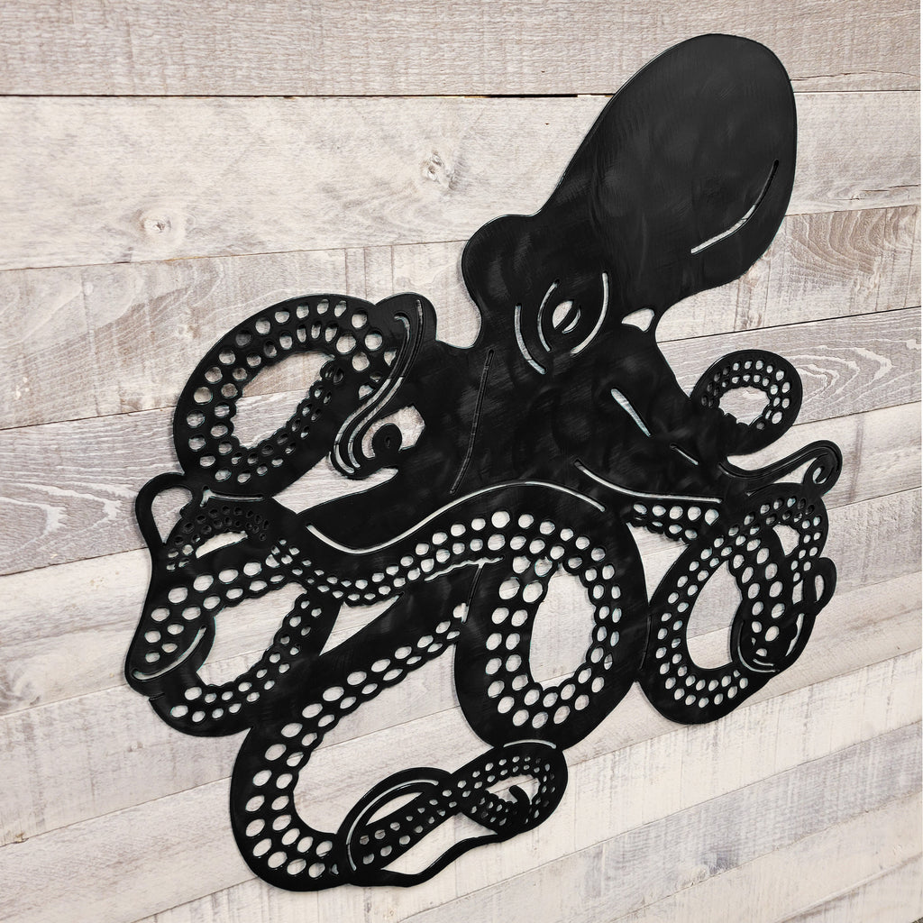 Black metal octopus wall art on a wooden background