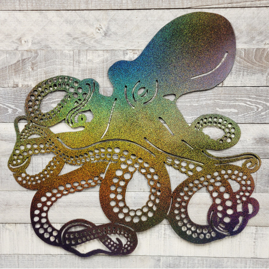 Metal cutout of an octopus with a gradient color effect on a wooden surface