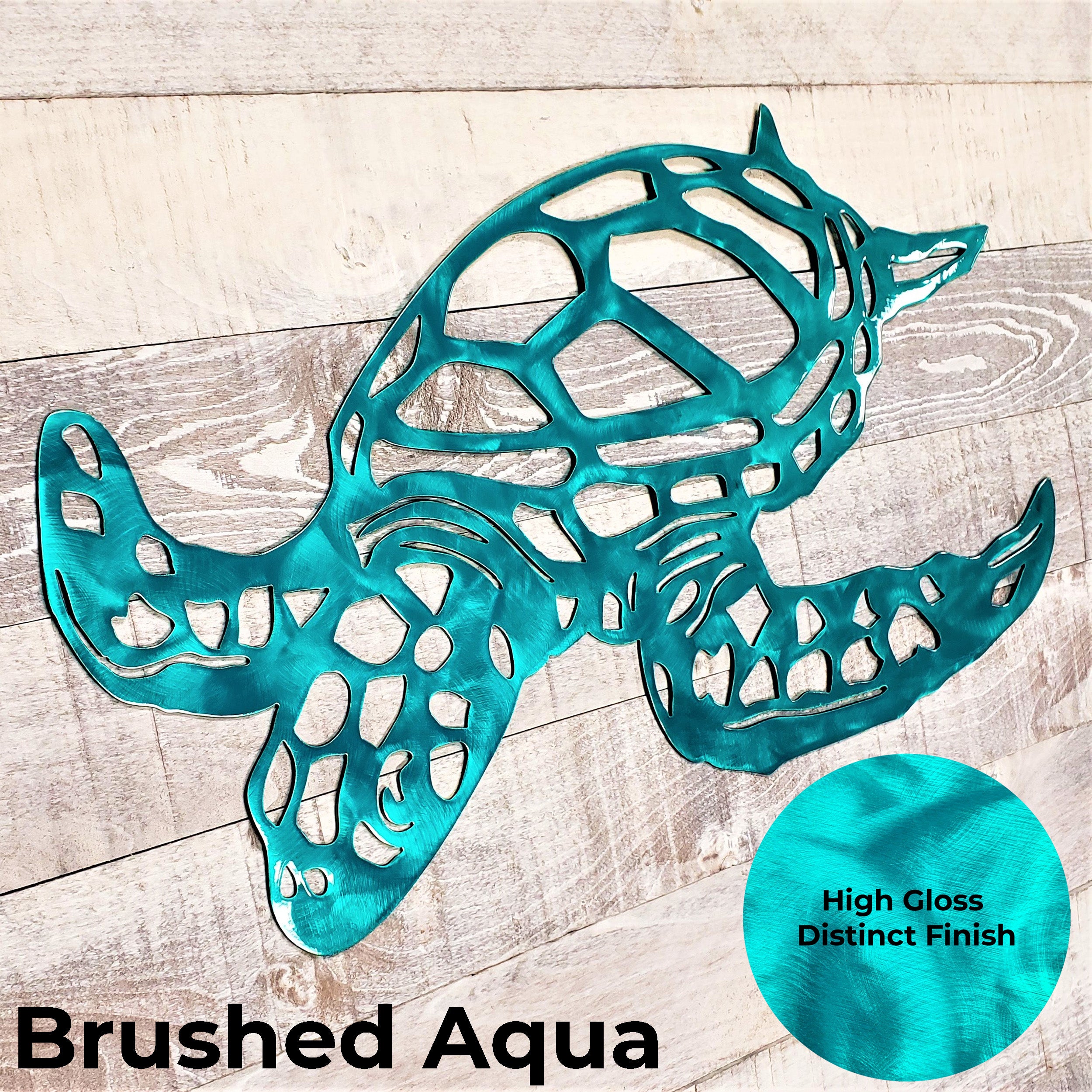 Metal wall art of a turtle in brushed aqua color on a wooden surface