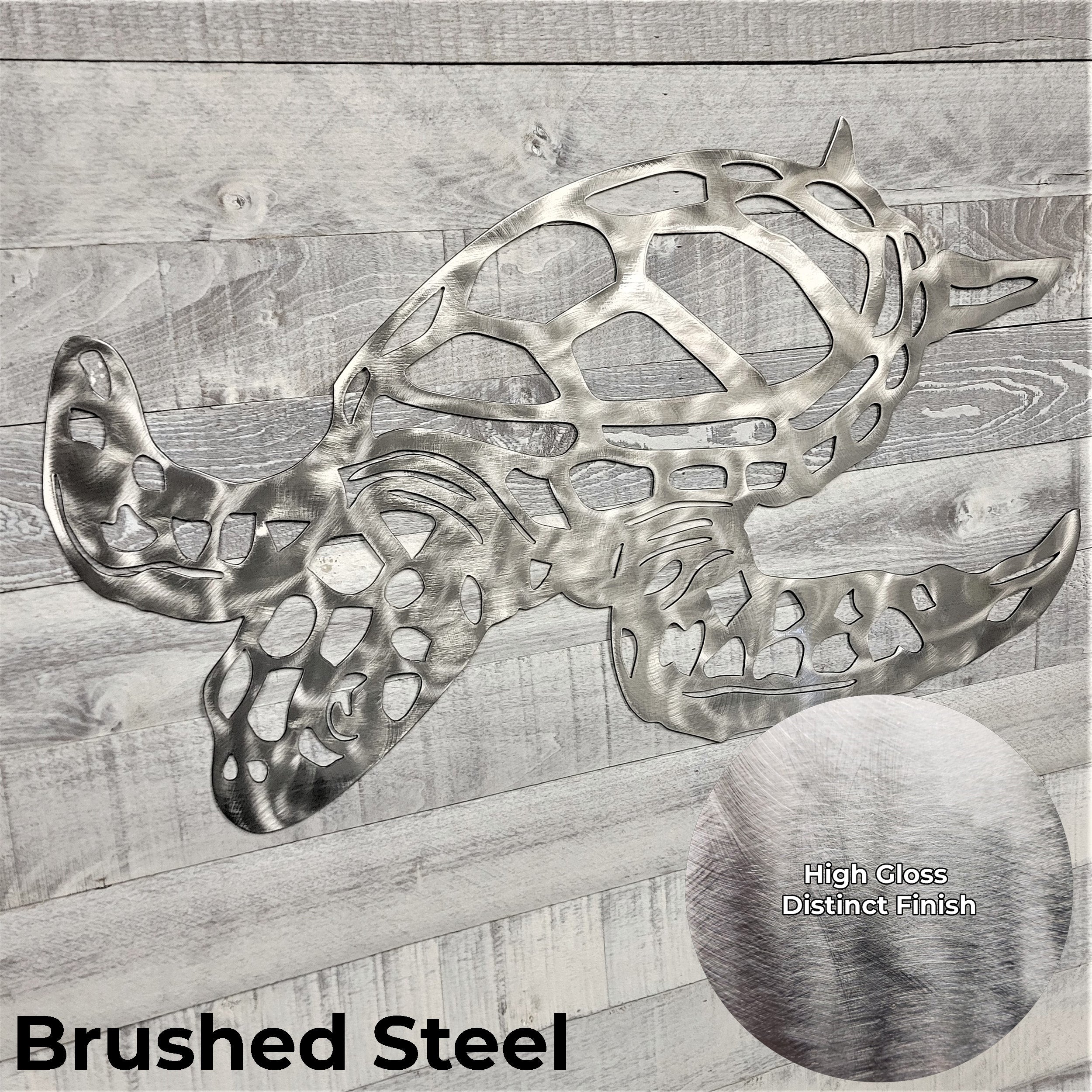 Metal turtle sculpture in brushed steel finish on a wooden background