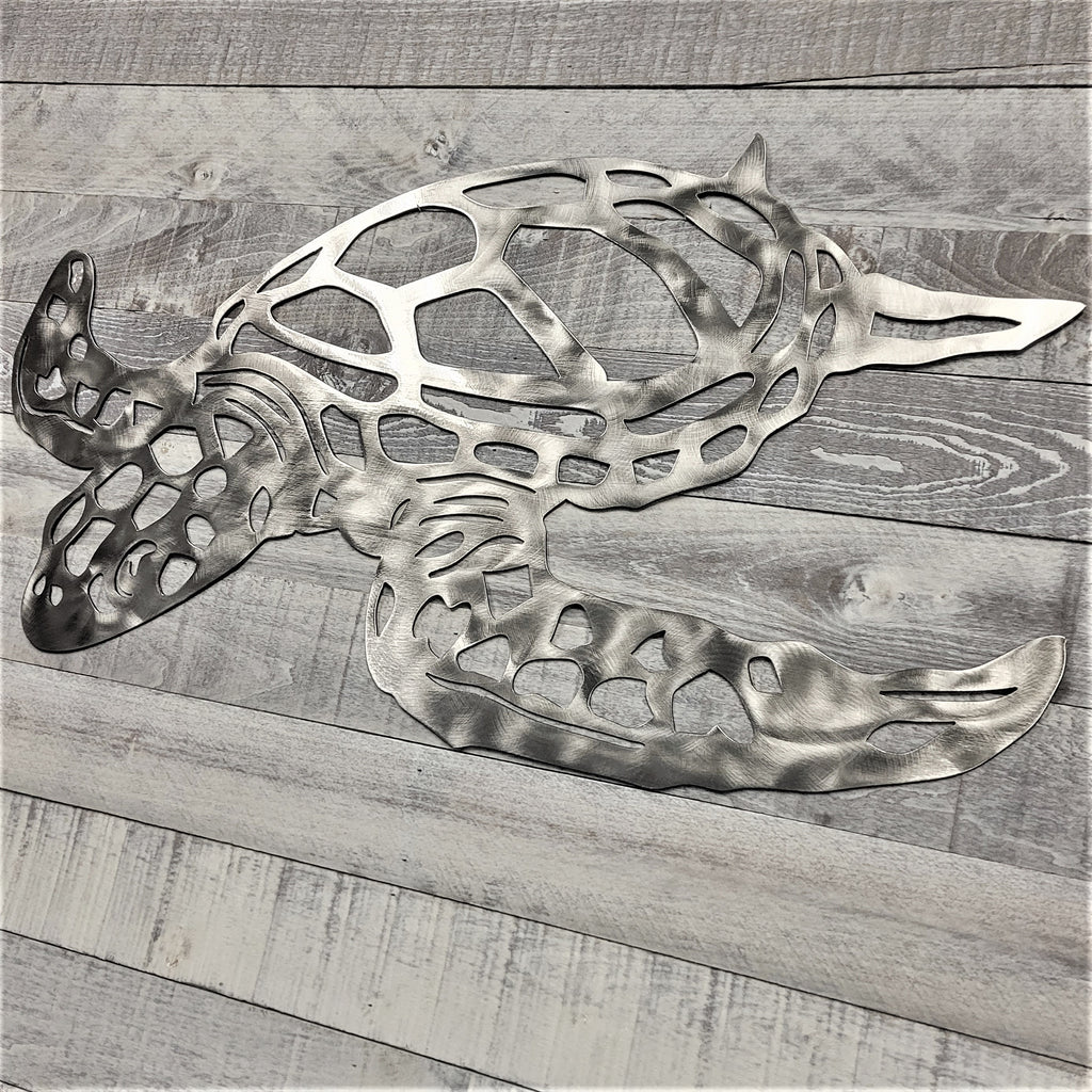 Metal turtle wall art on a wooden surface