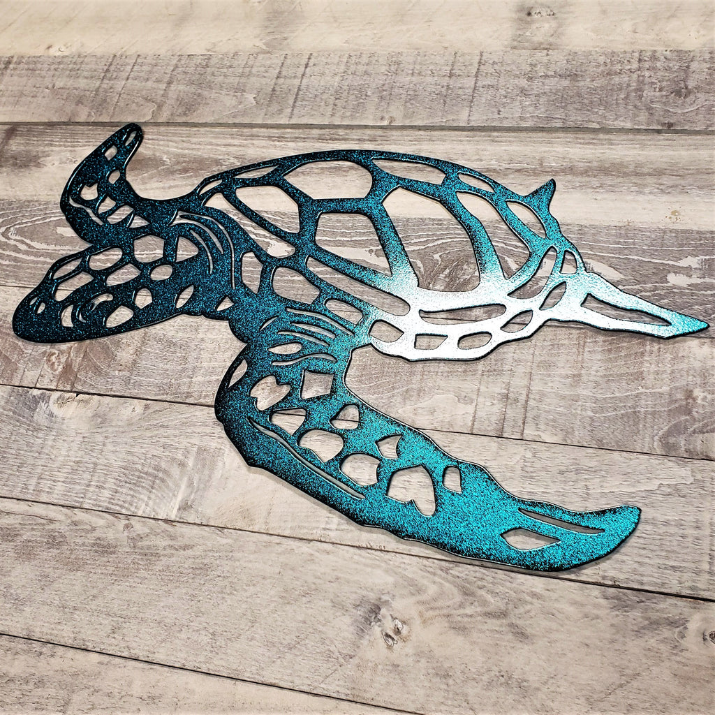 Metal turtle metal wall art with a blue gradient finish on a wooden surface