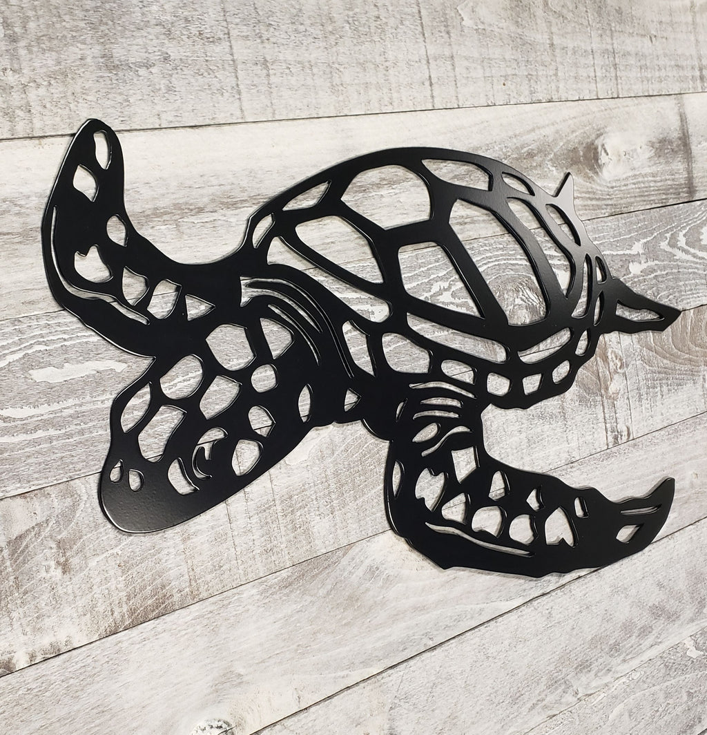 Black metal turtle sculpture on a wooden surface