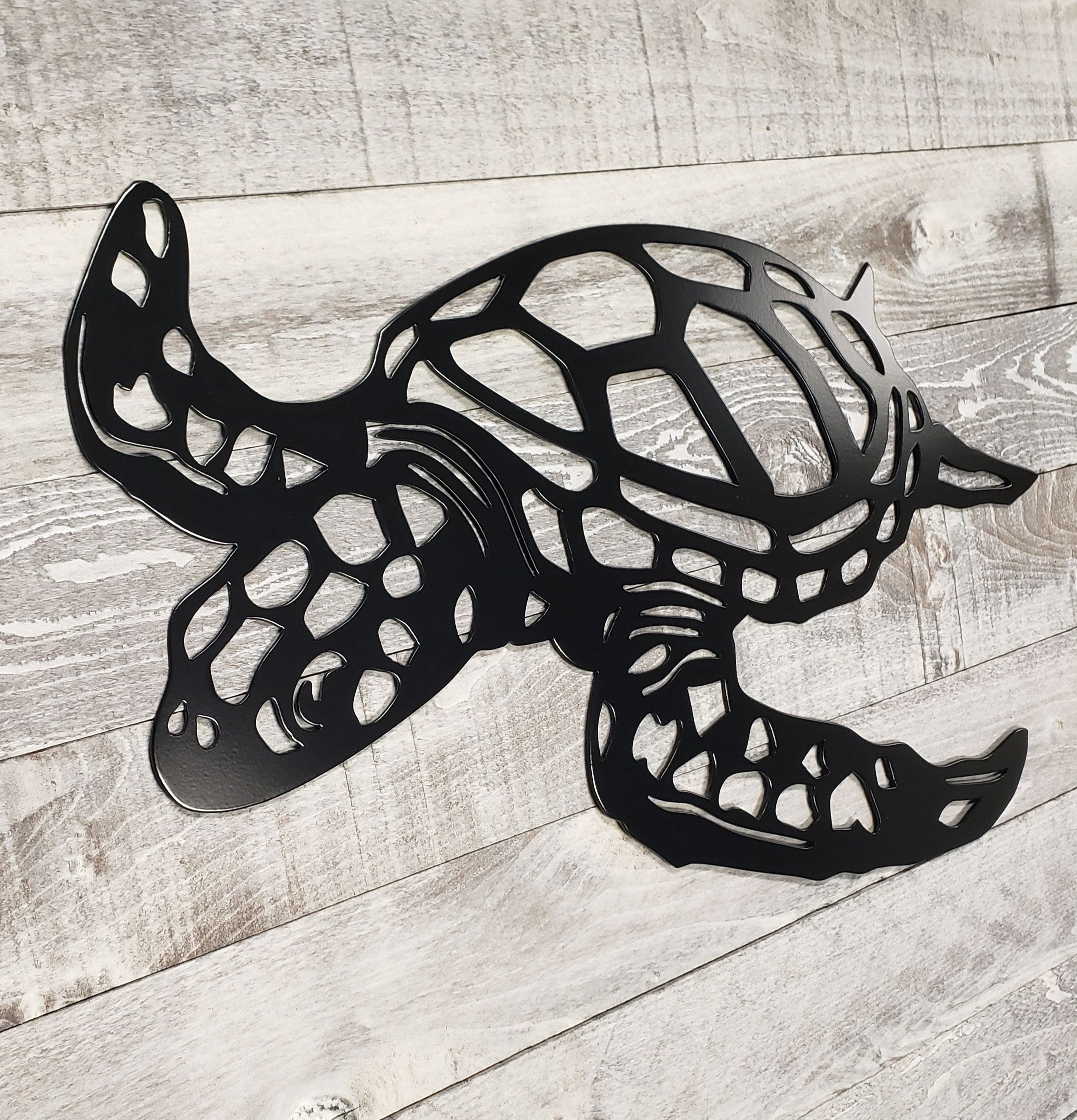 Black metal turtle sculpture on a wooden surface