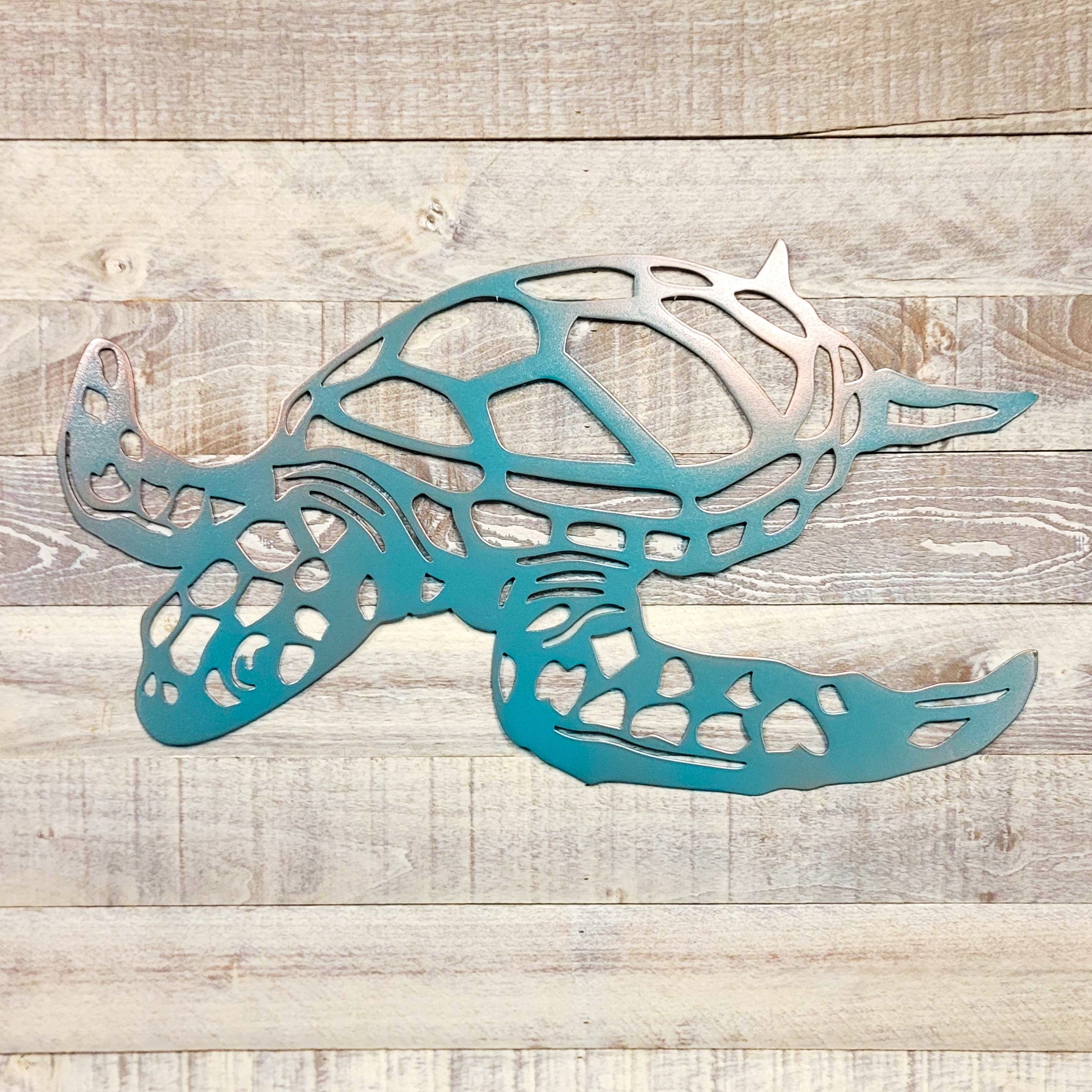 Metal wall art of a turtle on a wooden surface