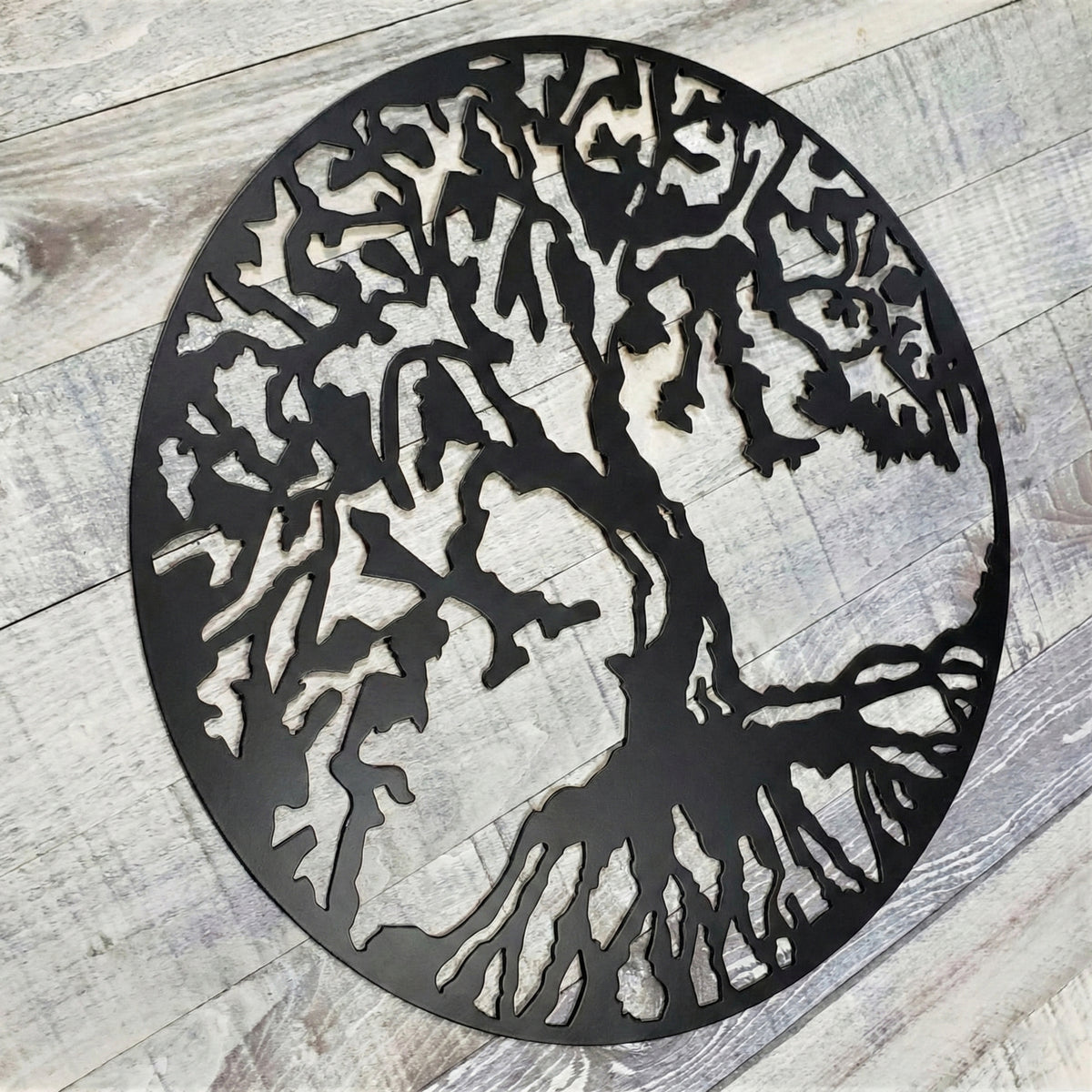Decorative metal tree wall art on a wooden floor