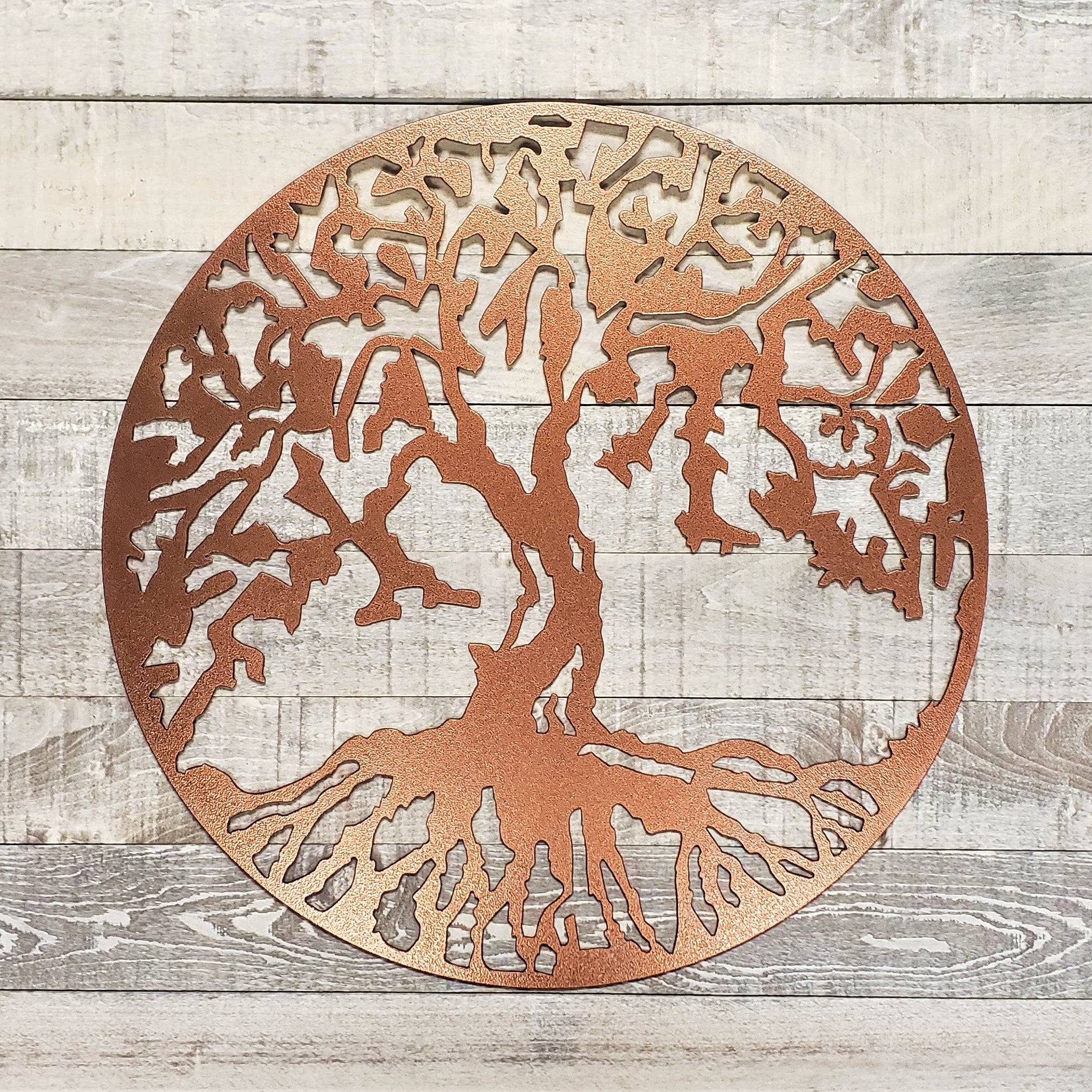 Decorative metal tree wall art on a wooden background