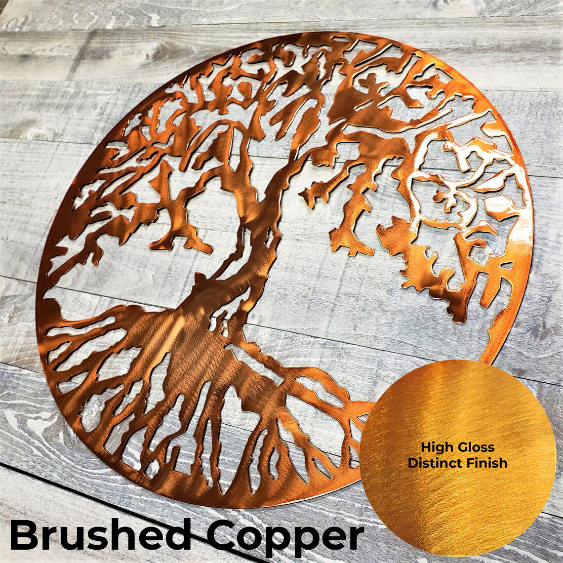 Metal tree of life wall art with a high gloss distinct finish on a wooden surface