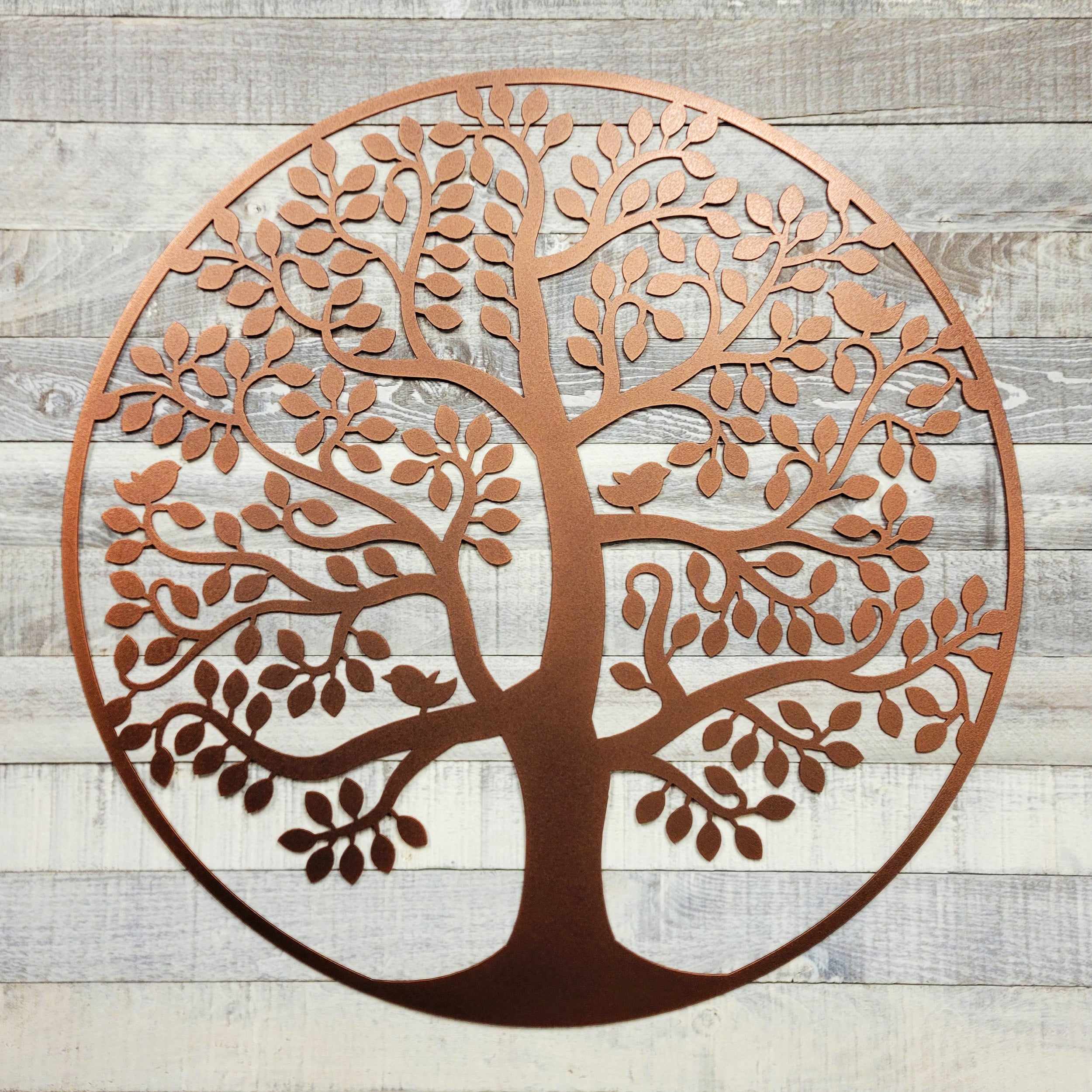 Decorative metal tree wall art on a wooden background