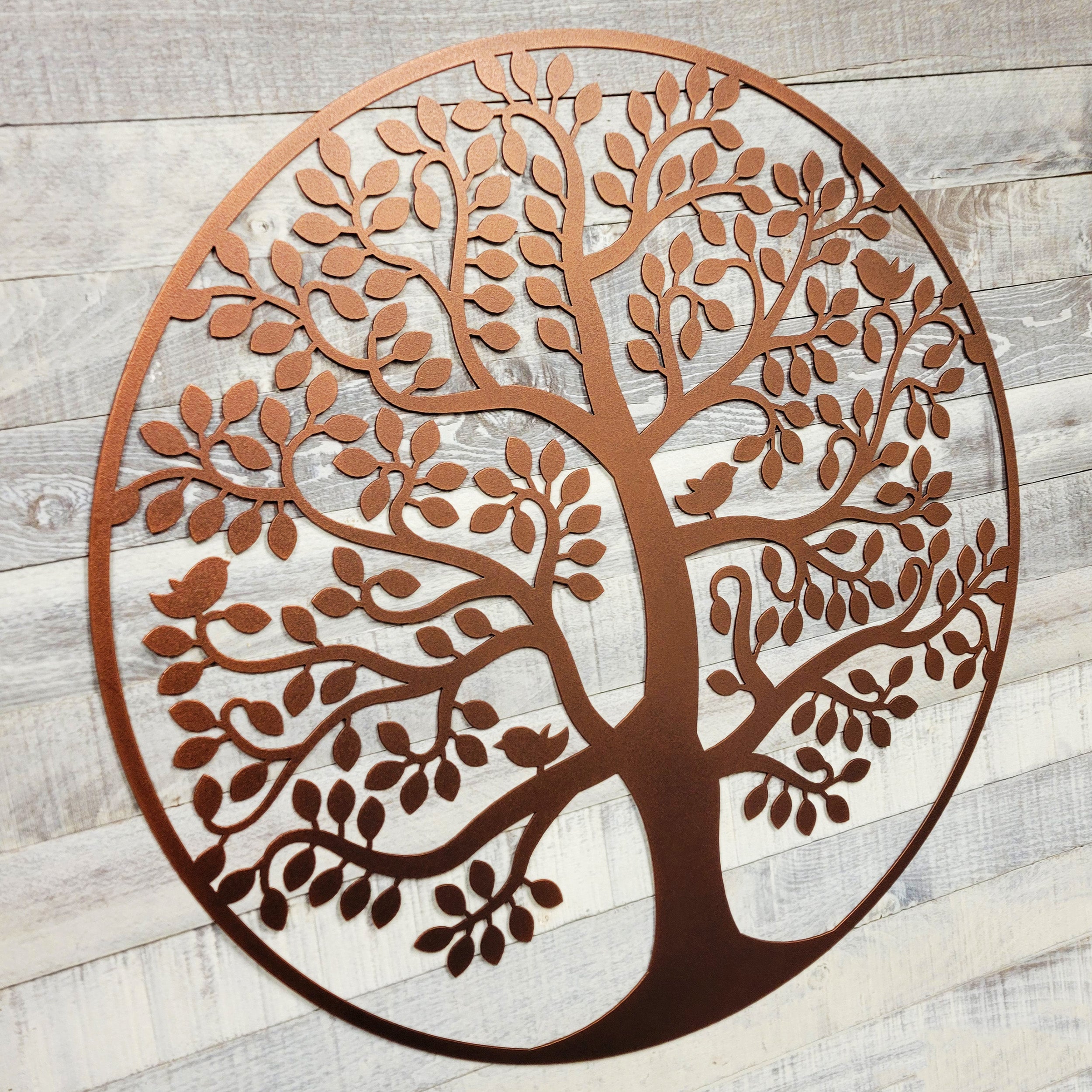 Decorative metal tree wall art on a wooden background