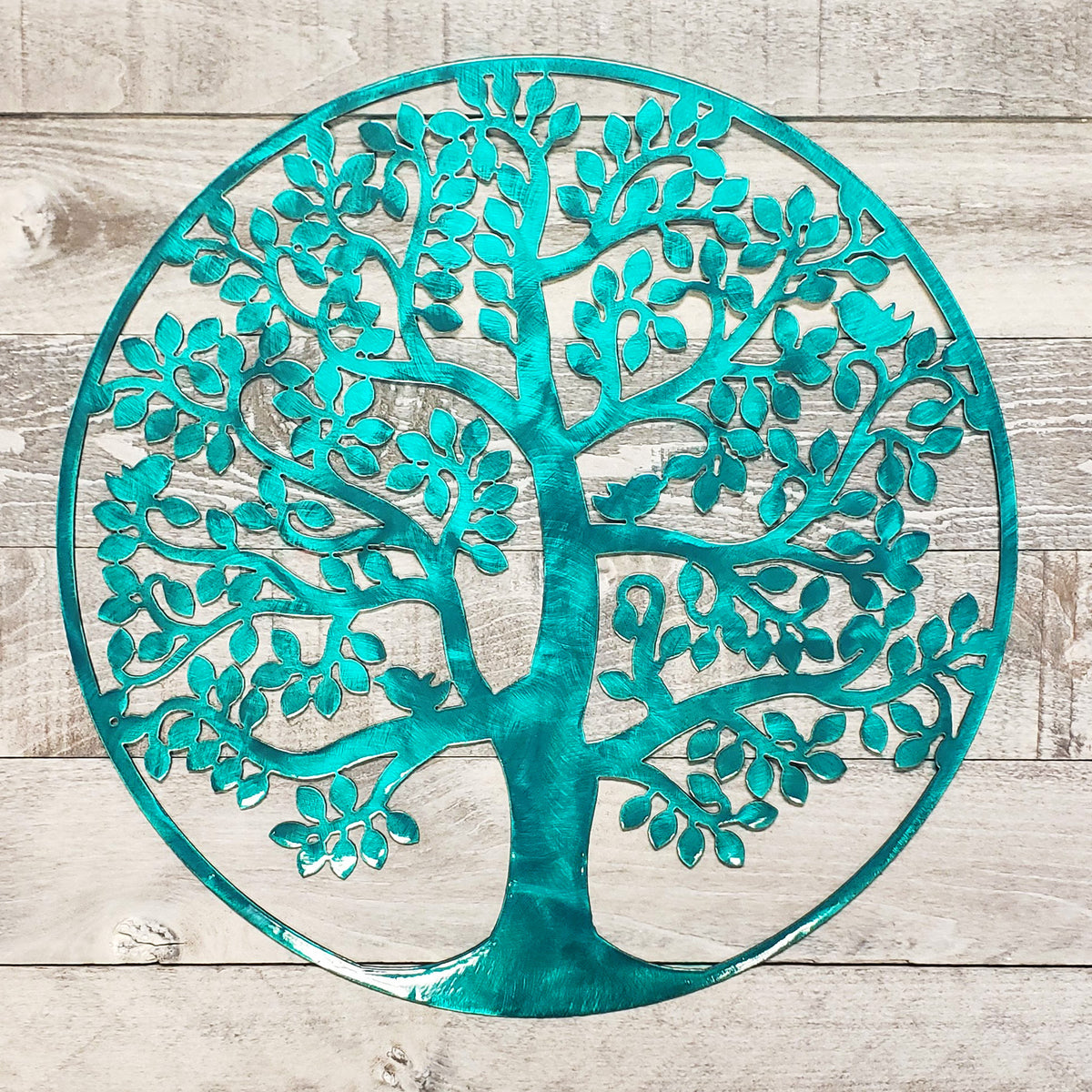 tree of life metal wall art with a brushed aqua finish on a wooden background
