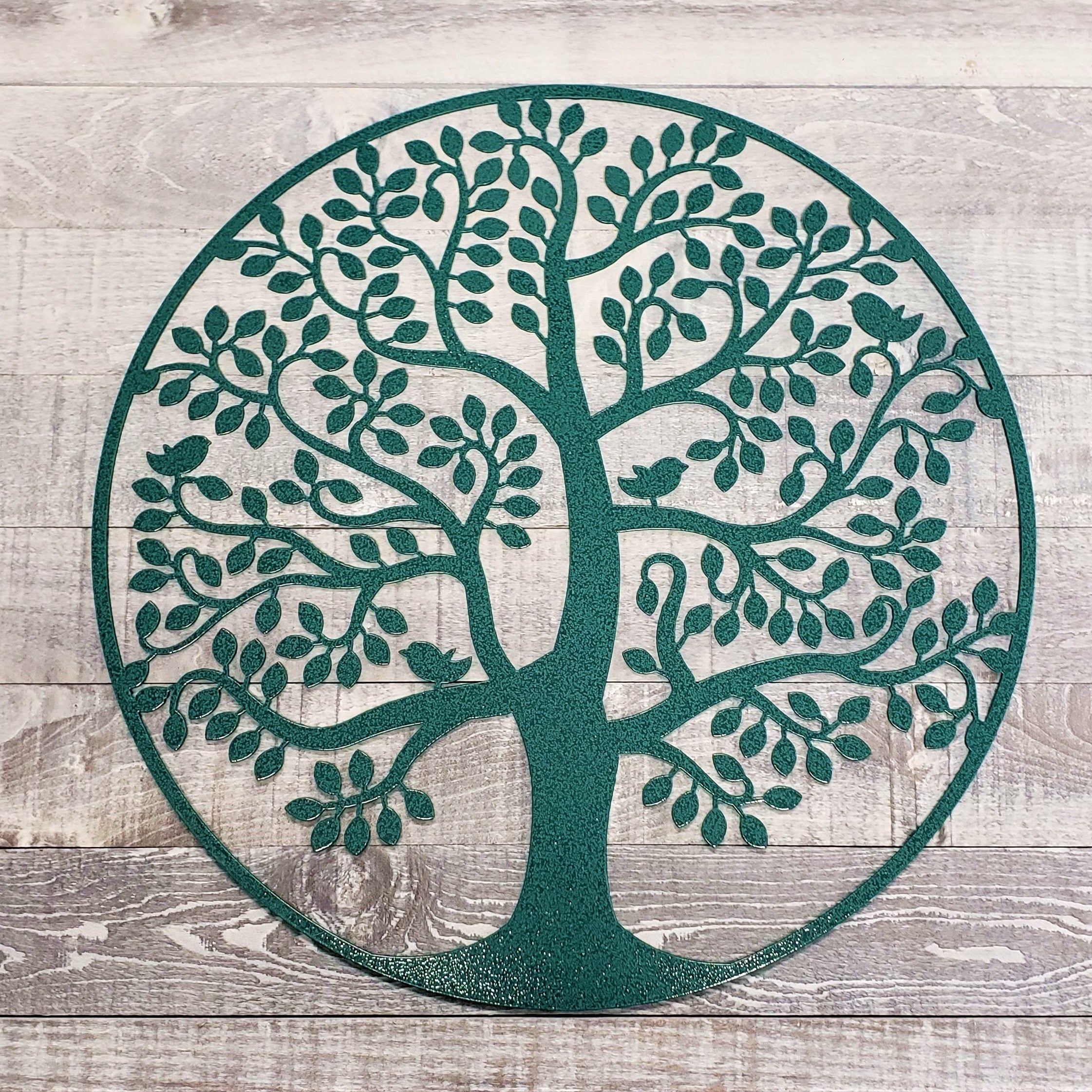 Decorative metal tree of life wall art on a wooden background