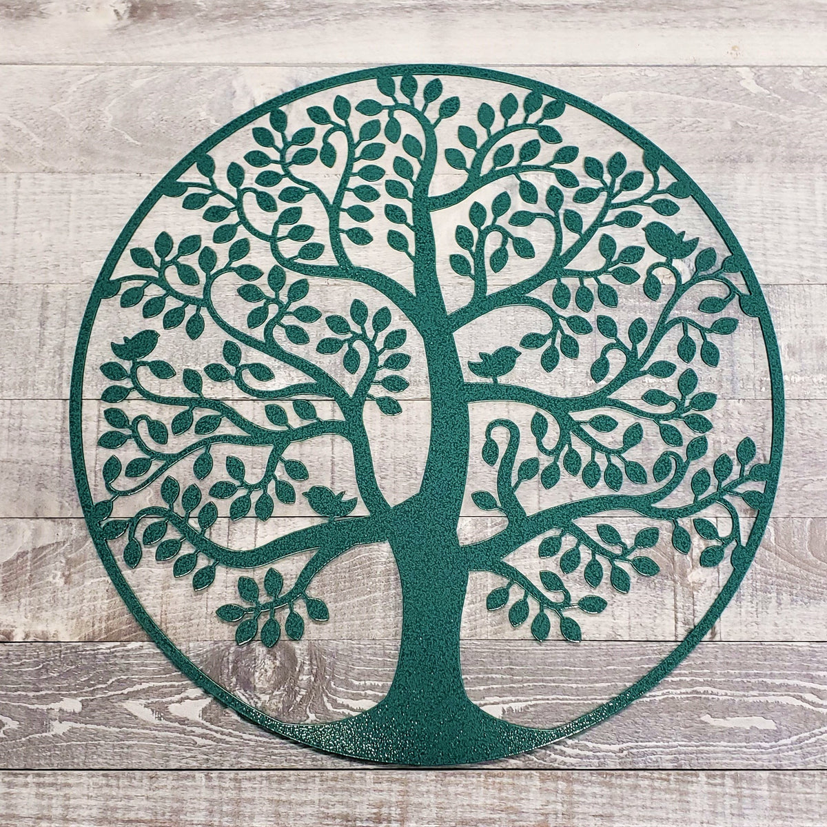 Decorative metal tree of life wall art on a wooden background