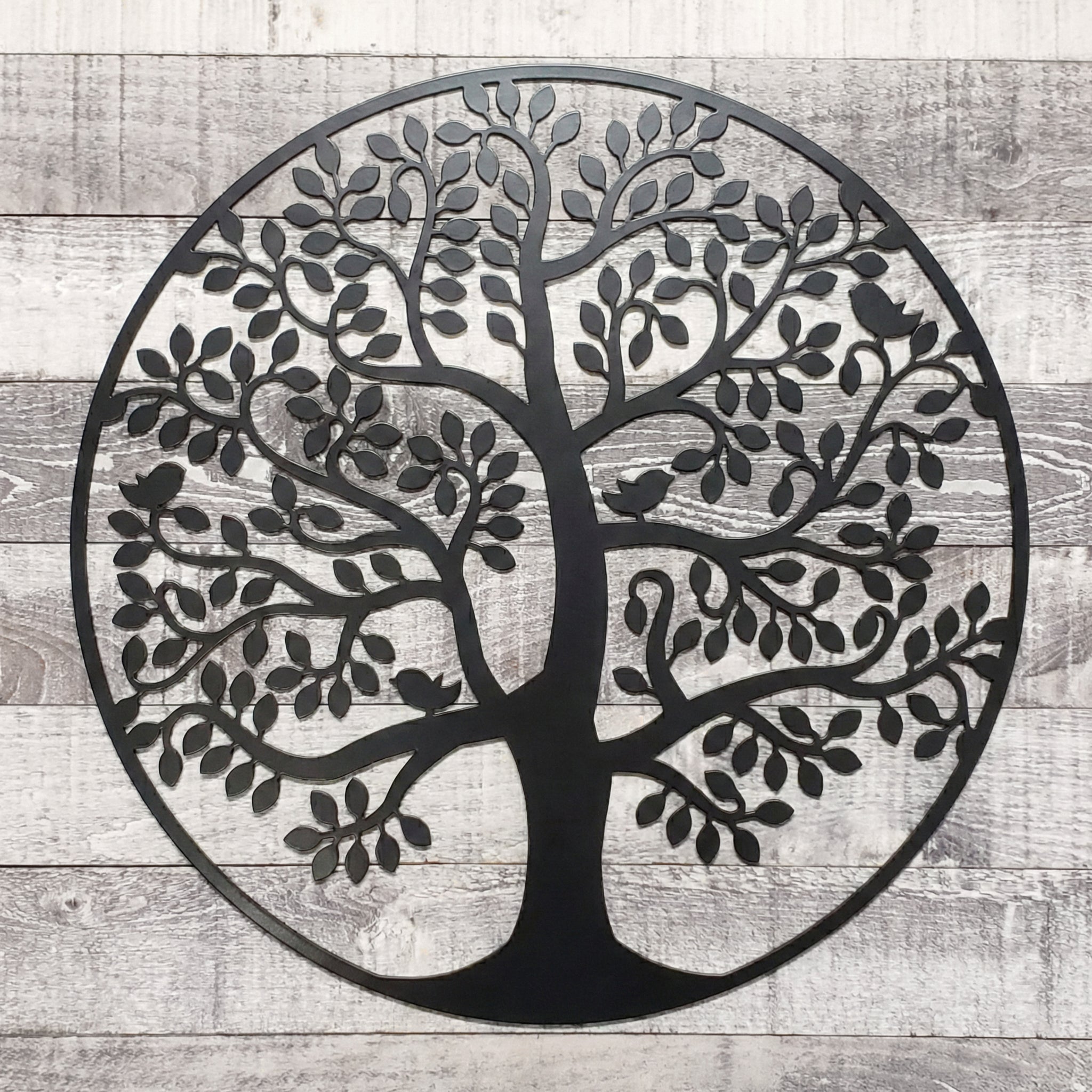 Black metal tree wall art on a wooden background