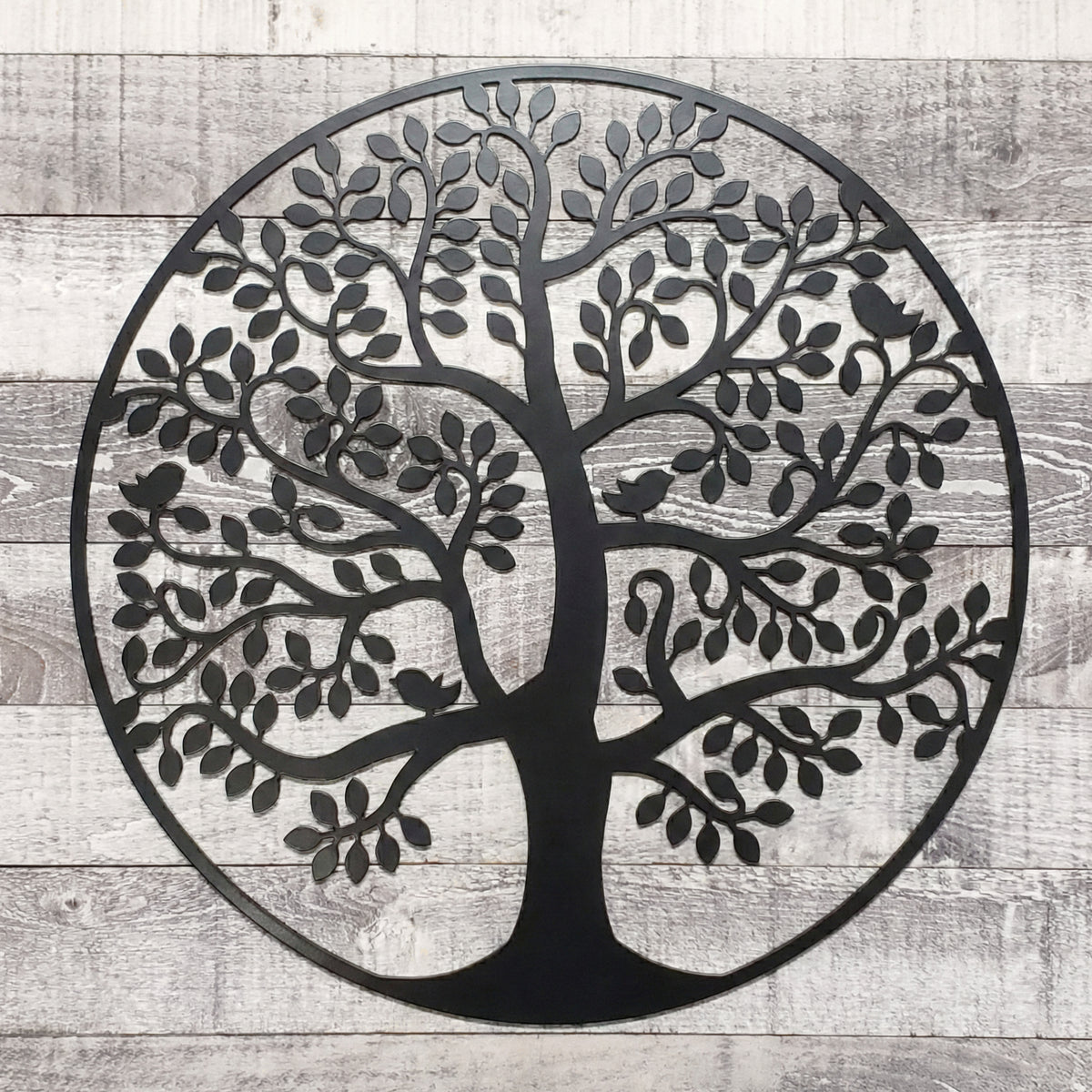 Black metal tree wall art on a wooden background