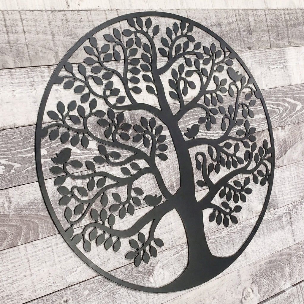 Decorative metal tree wall art on a wooden surface