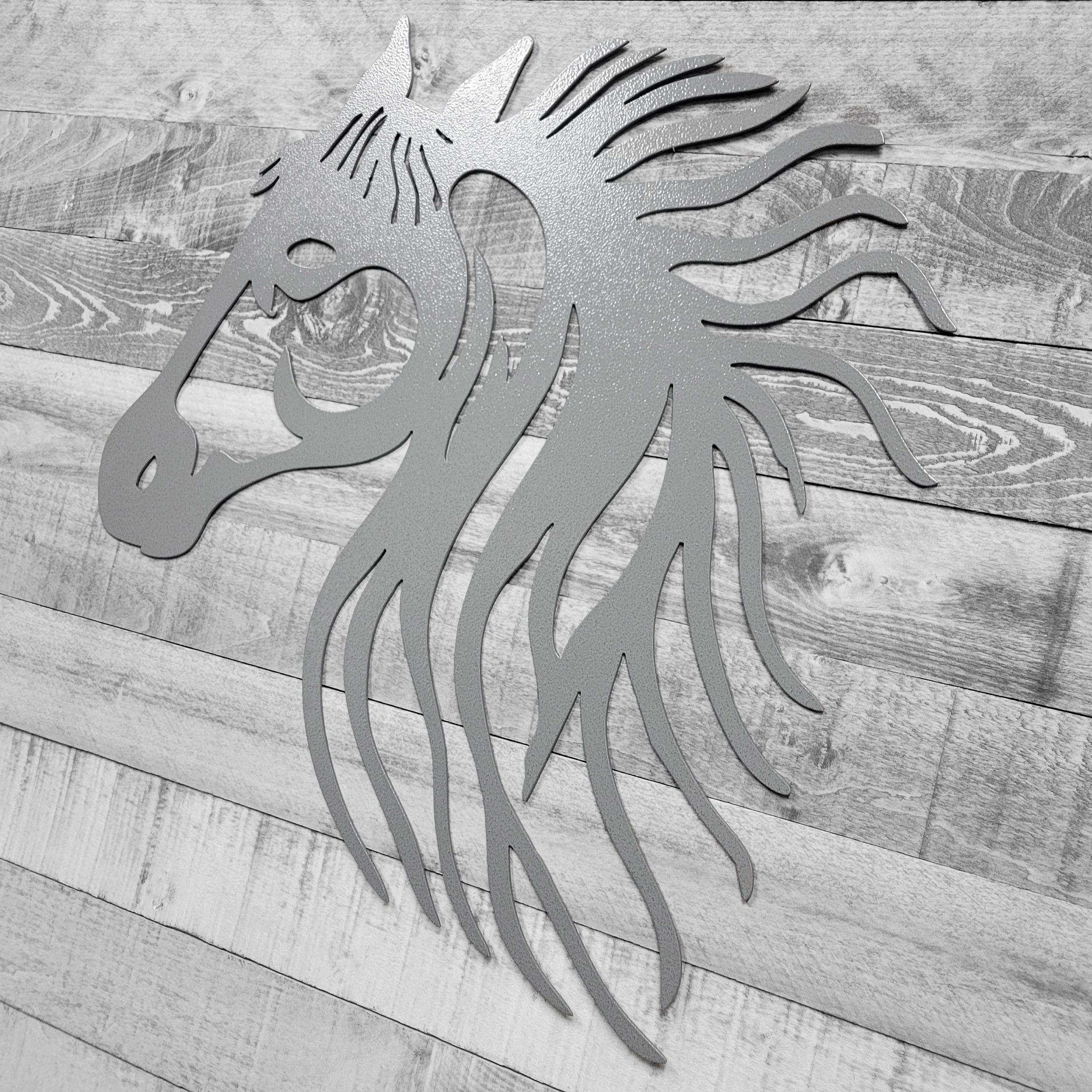silver metal horse head wall art on a wooden background