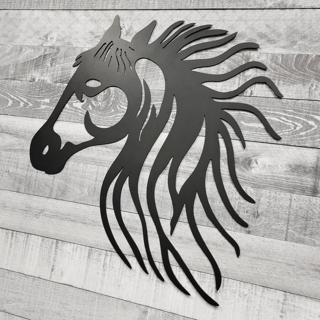 black metal horse head wall art on a wooden background