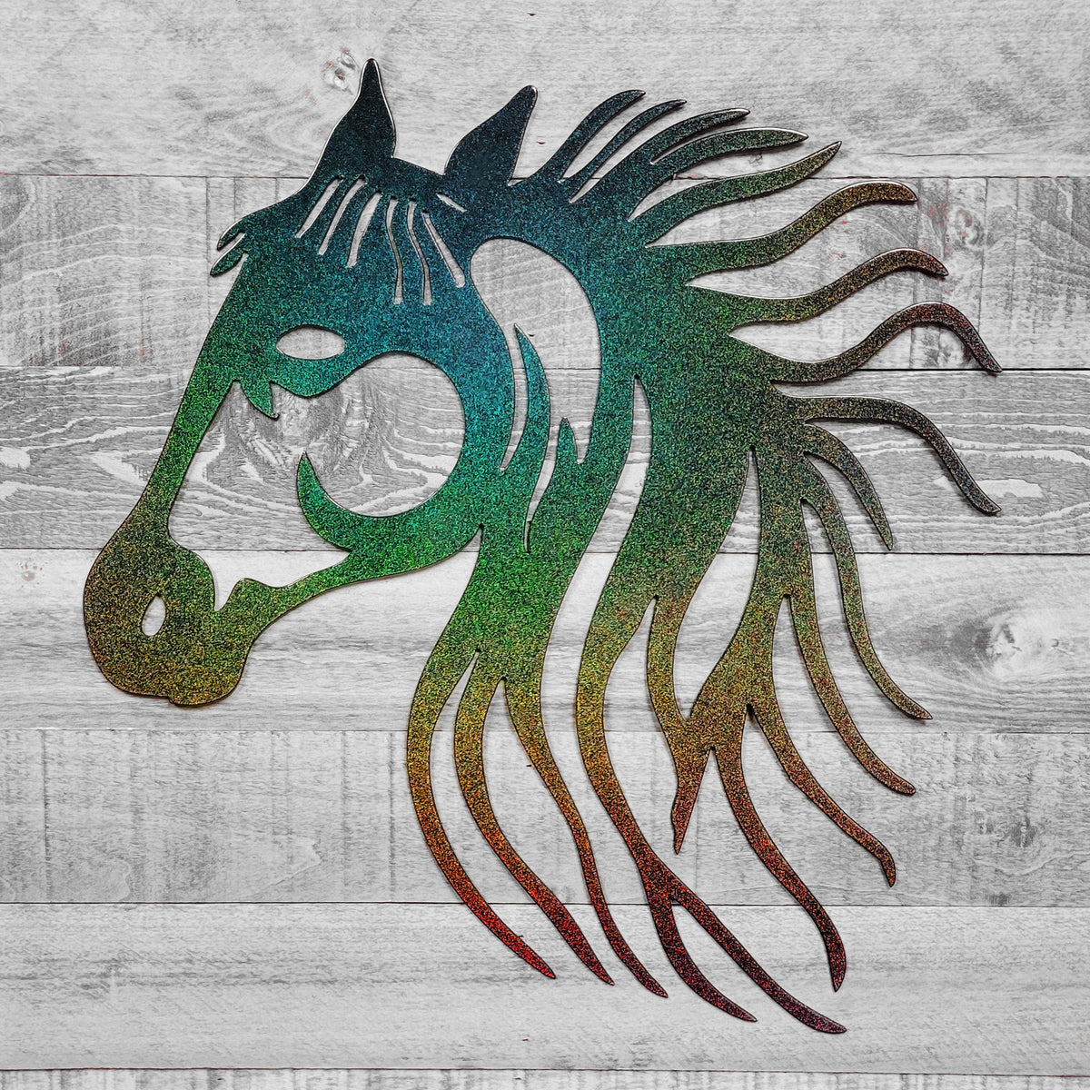 rainbow-shifting metallic metal horse head wall art on a wooden background
