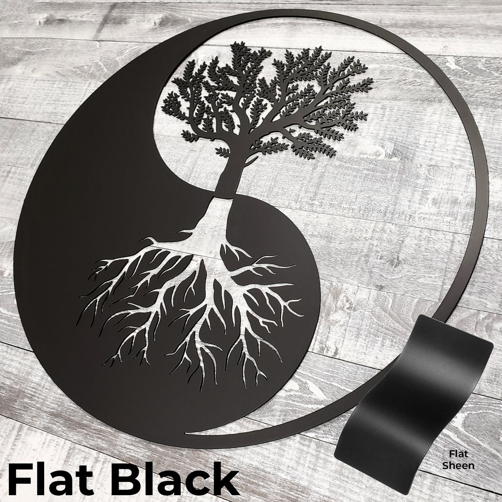 Decorative wall art with a tree design inside a yin yang symbol on a wooden surface.