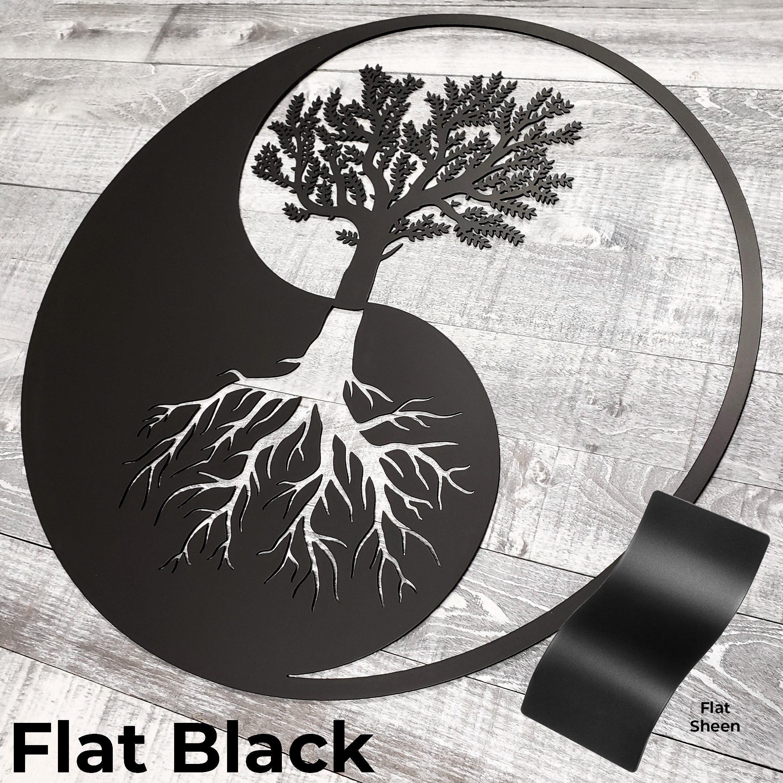 Decorative wall art with a tree design inside a yin yang symbol on a wooden surface.