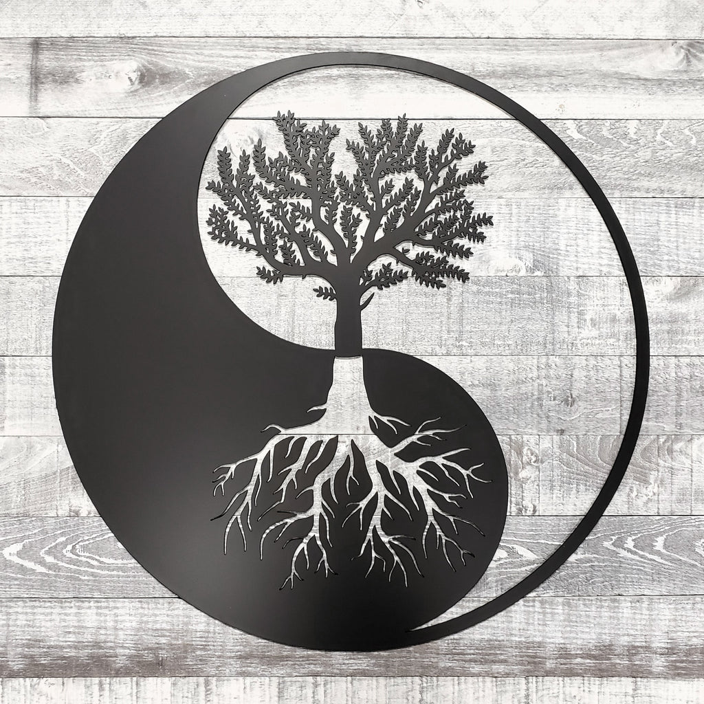 Yin yang symbol with a tree and roots on a wooden background