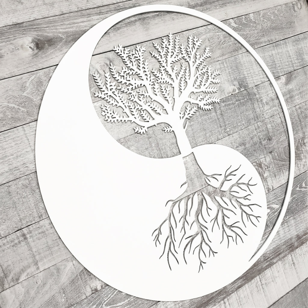 Decorative metal tree with branches and roots on a wooden surface