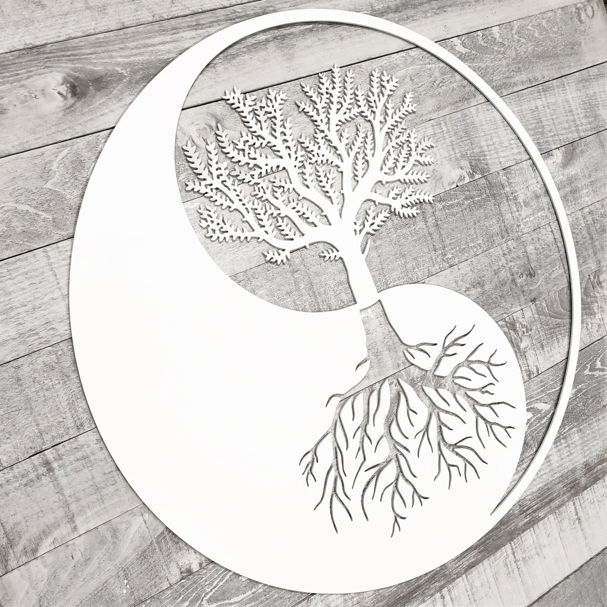 Decorative metal tree with branches and roots on a wooden surface