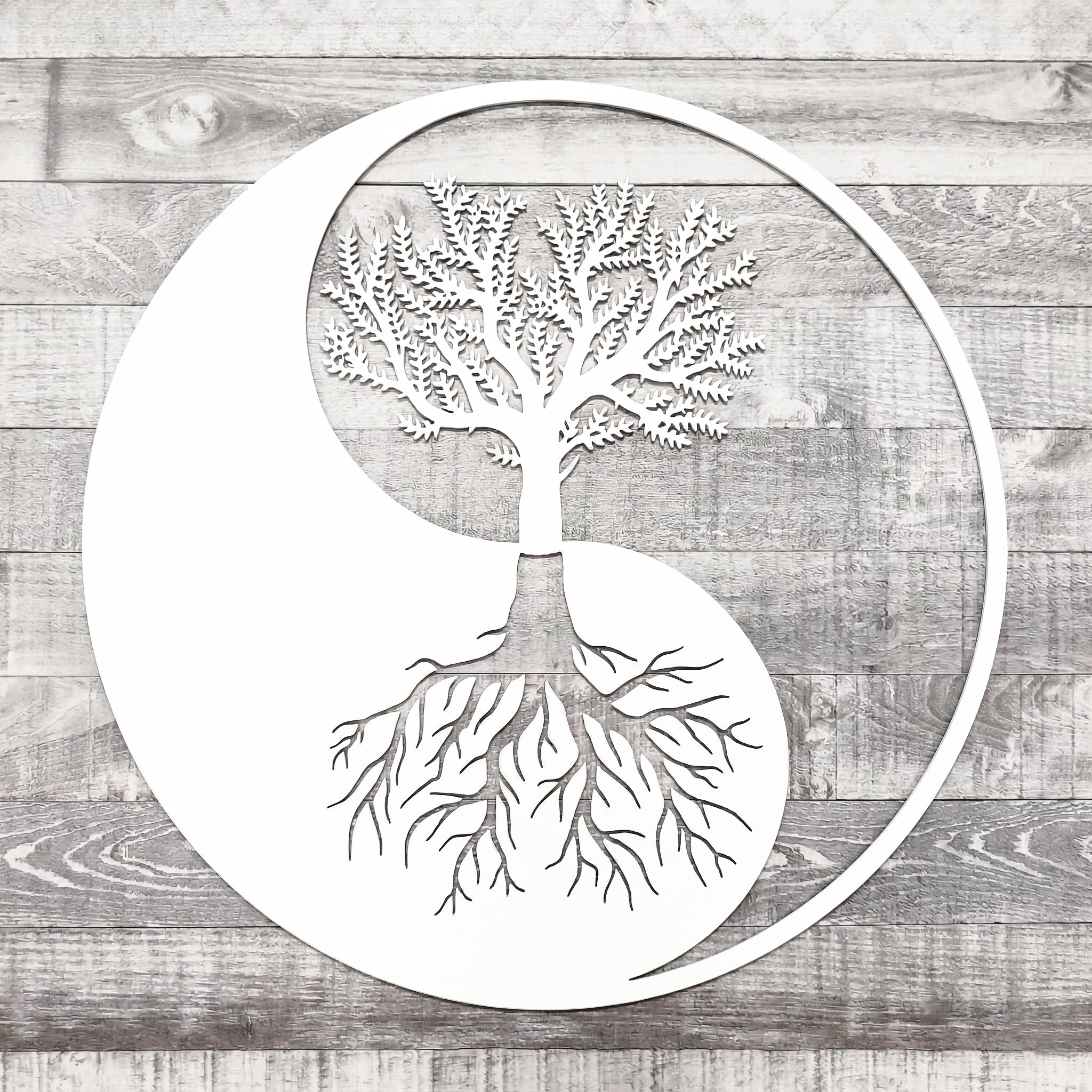 Decorative metal wall art with a tree design on a wooden background