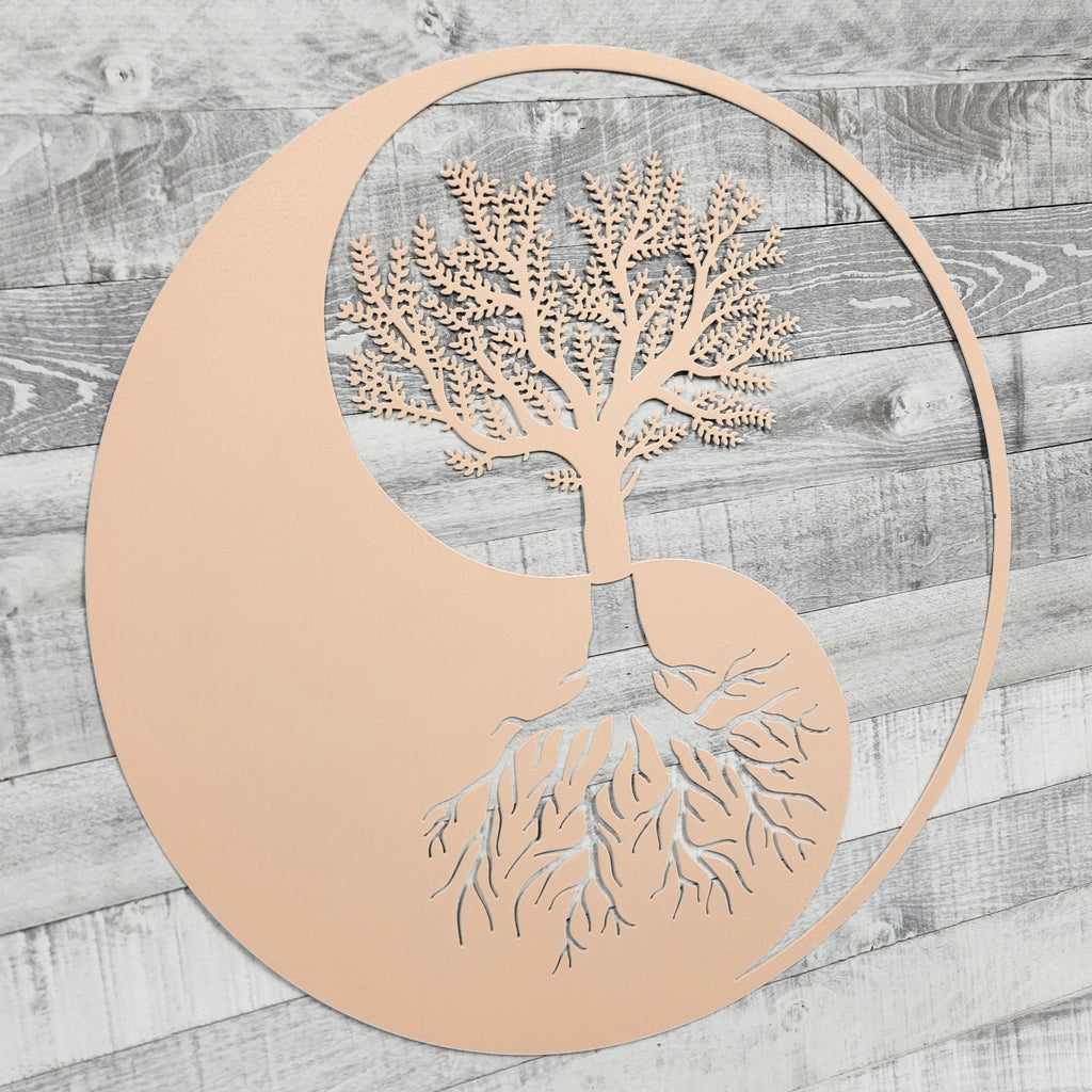 Decorative wall art with a tree design inside a yin yang symbol on a wooden background