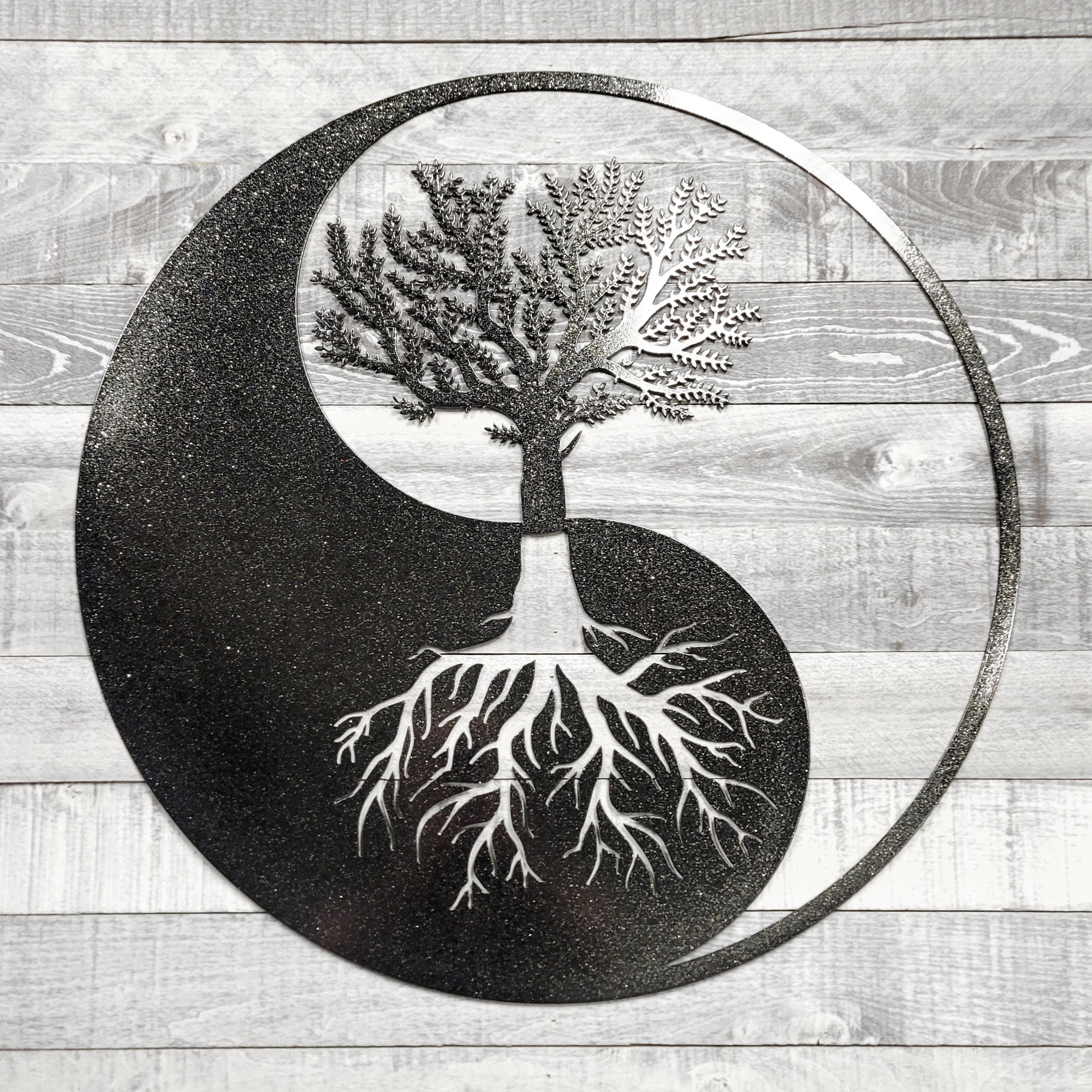 Yin yang symbol with a tree and roots on a wooden background